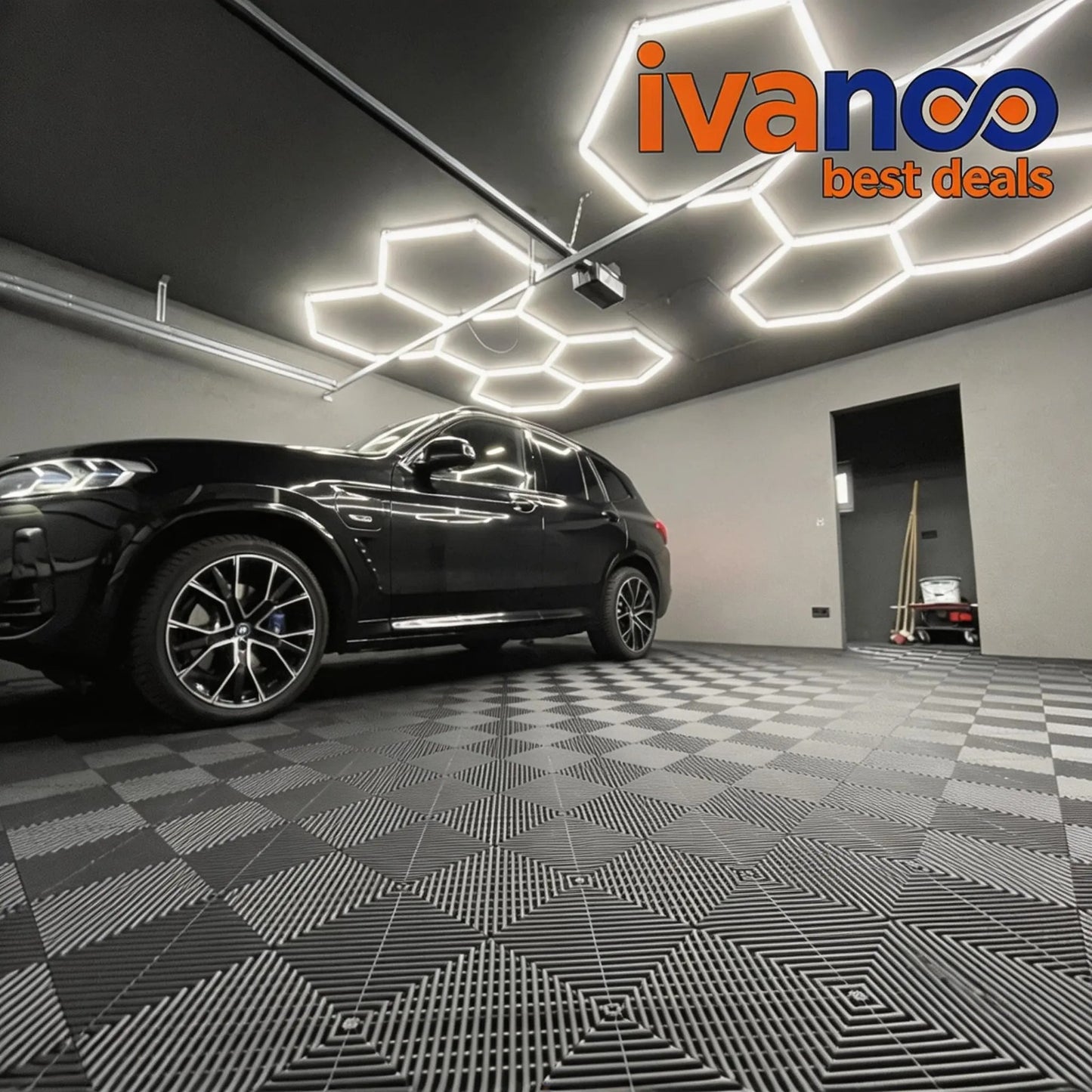 Car in a showroom with geometric ceiling lights and 'ivanoo best deals' logo.