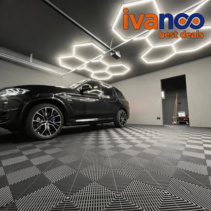 Car in a showroom with geometric ceiling lights and 'ivanoo best deals' logo.